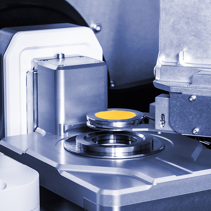 装有黄色粉末的样品架位于 XRDynamic Autosampler 的测量台上方。